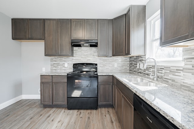 kitchen with black appliances, backsplash, ventilation hood, and a sink