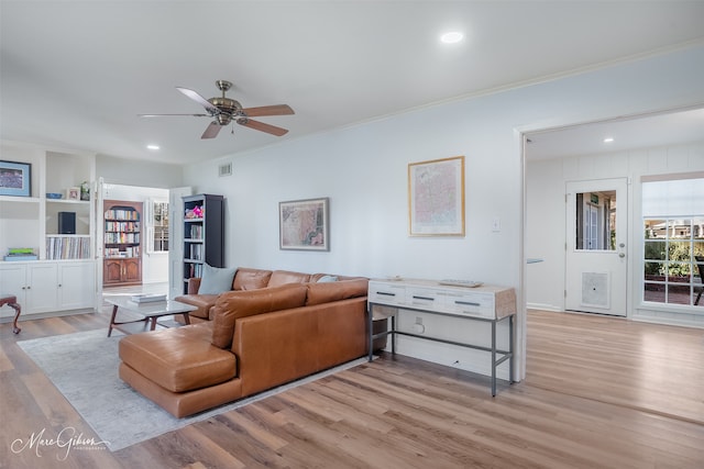 living area featuring ceiling fan, recessed lighting, visible vents, ornamental molding, and light wood finished floors