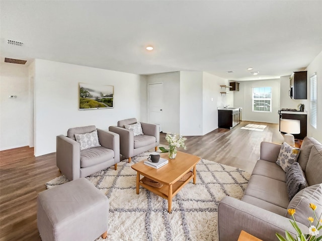 living room with wood finished floors, visible vents, and recessed lighting