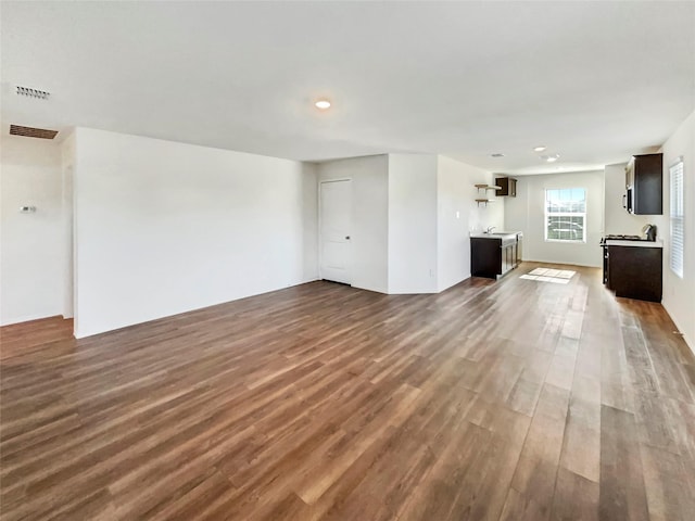 unfurnished living room with dark wood-style floors and visible vents