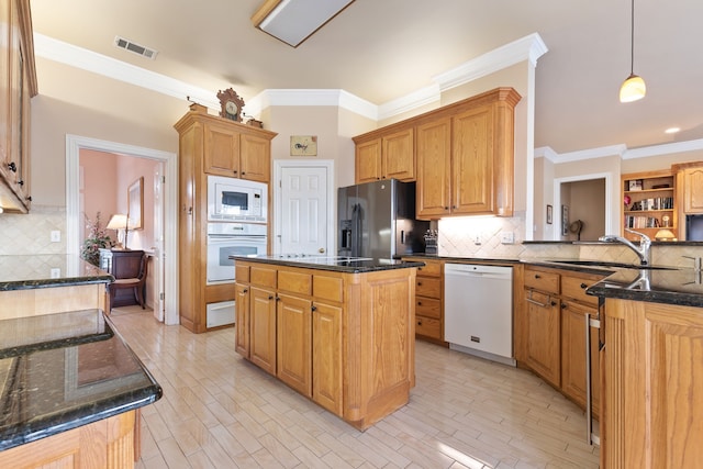 kitchen featuring visible vents, a center island, hanging light fixtures, black appliances, and a sink