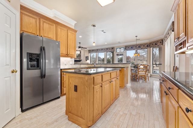 kitchen with a peninsula, hanging light fixtures, light wood-type flooring, a center island, and stainless steel fridge