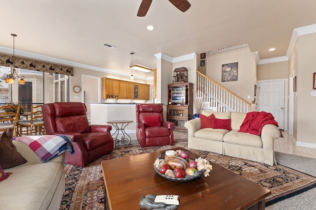 living area featuring ornamental molding, recessed lighting, visible vents, and stairway