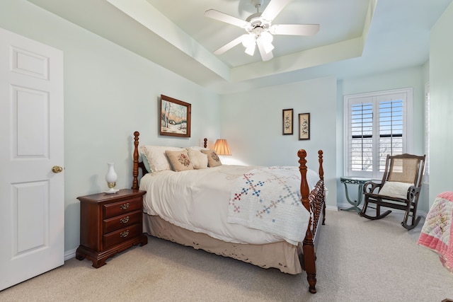 bedroom with baseboards, a tray ceiling, a ceiling fan, and light colored carpet