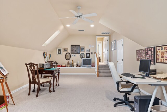 office space with carpet floors, vaulted ceiling with skylight, visible vents, and baseboards