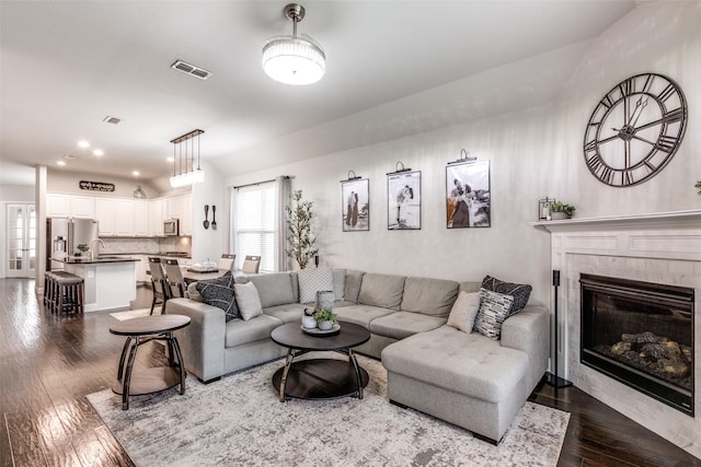 living area with dark wood-style floors, recessed lighting, visible vents, and a tile fireplace