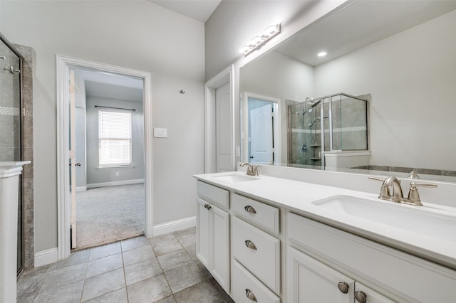 bathroom featuring baseboards, double vanity, a sink, and a shower stall