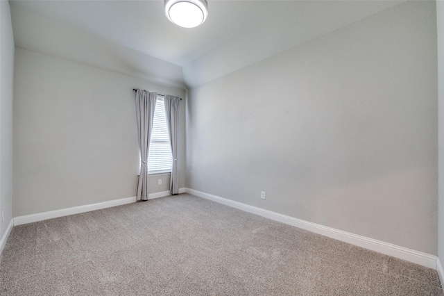 carpeted spare room featuring baseboards