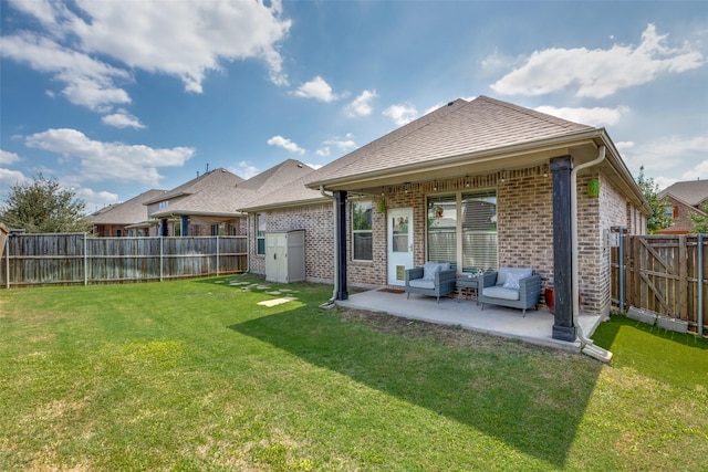 back of property featuring a patio area, a fenced backyard, a lawn, and brick siding