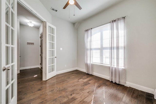 empty room featuring french doors, dark wood-style flooring, visible vents, and baseboards