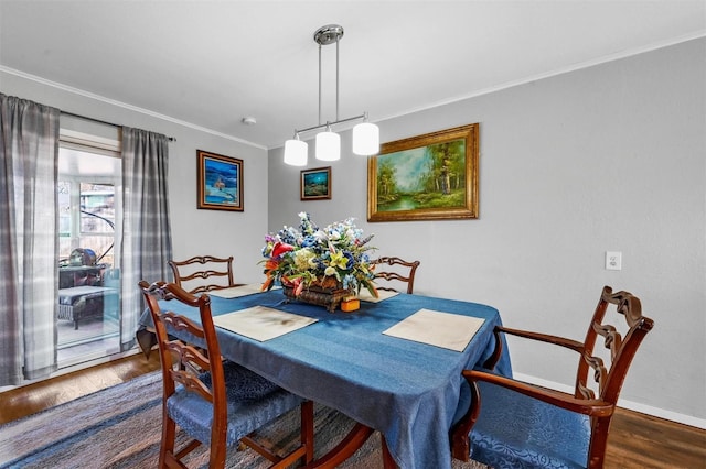 dining area featuring dark wood-type flooring, crown molding, and baseboards