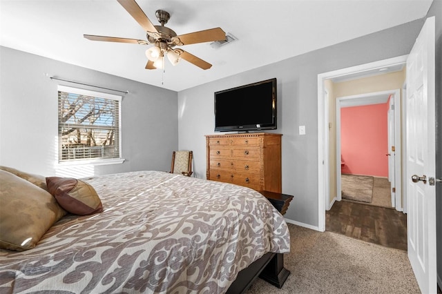 carpeted bedroom with a ceiling fan, visible vents, and baseboards