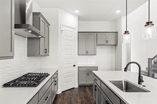 551 Baker Ct, Fate, TX 75189 - kitchen featuring wall chimney exhaust hood, gray cabinets, a sink, stainless steel gas cooktop, and dark wood-type flooring