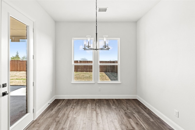 551 Baker Ct, Fate, TX 75189 - unfurnished dining area featuring a chandelier, wood finished floors, and baseboards