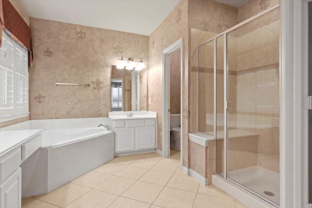 bathroom featuring a garden tub, toilet, a shower stall, vanity, and tile patterned flooring