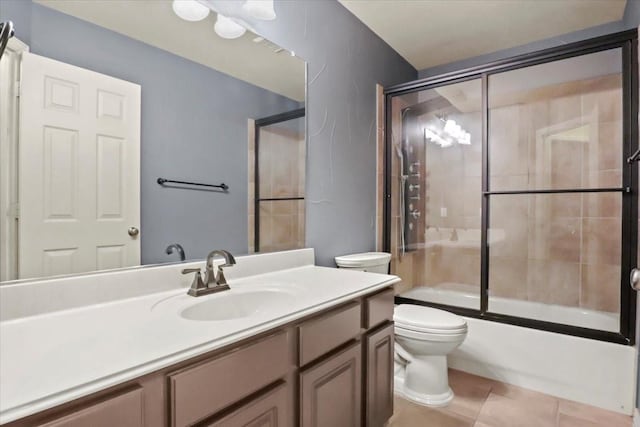 bathroom with shower / bath combination with glass door, vanity, toilet, and tile patterned floors