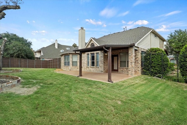 rear view of house featuring a fenced backyard, a chimney, a yard, a patio area, and brick siding