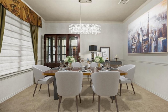 carpeted dining space with an inviting chandelier, baseboards, and ornamental molding