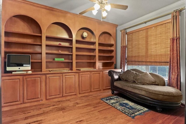 sitting room featuring light wood-style floors, a ceiling fan, and crown molding