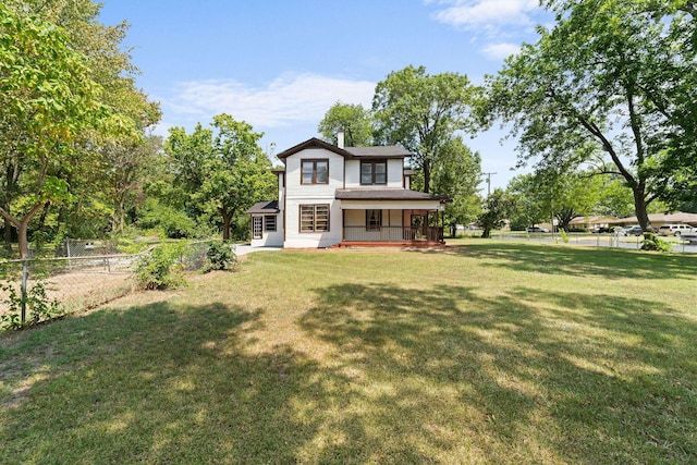 rear view of property with fence private yard, a chimney, a porch, and a lawn