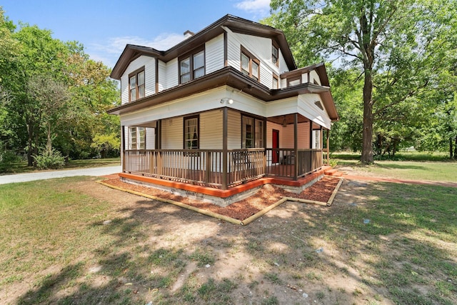 back of property featuring a porch and a lawn