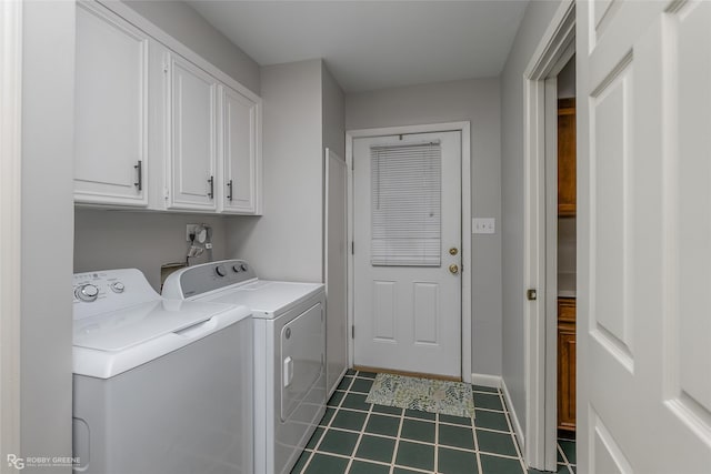 washroom with cabinet space, baseboards, washer and clothes dryer, and dark tile patterned flooring