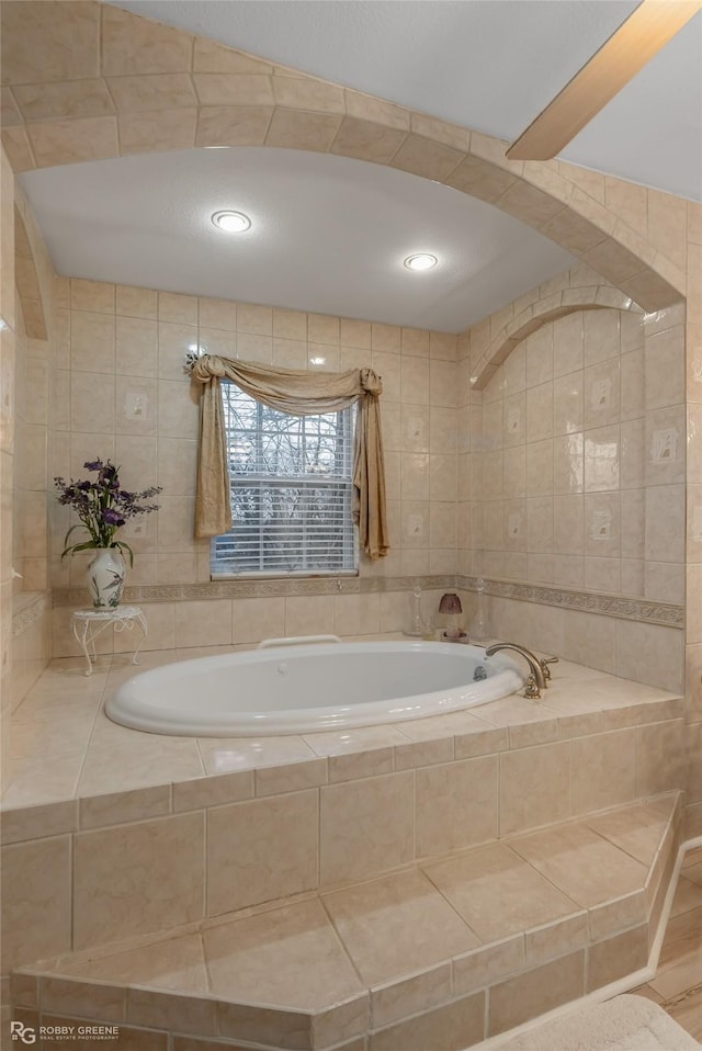 full bath featuring a garden tub and tile walls