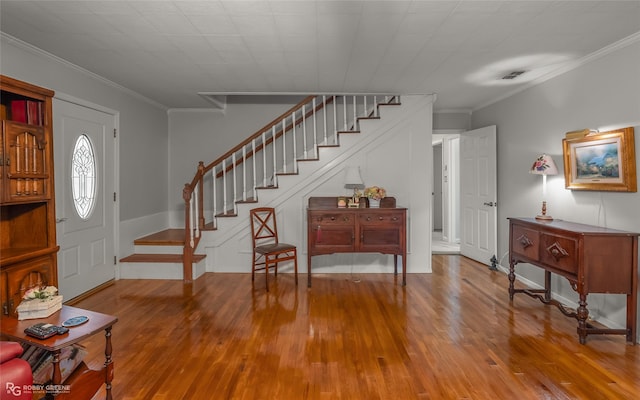 foyer featuring stairs, crown molding, and wood finished floors