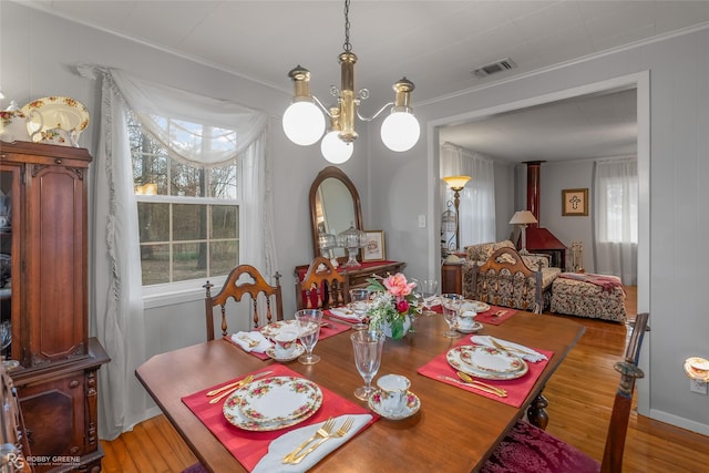 dining area with light wood finished floors, plenty of natural light, and visible vents