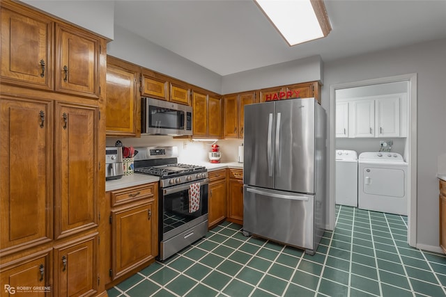 kitchen with stainless steel appliances, washing machine and dryer, light countertops, and brown cabinets