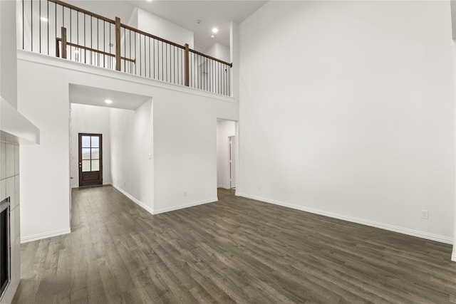 279 Bright Alcove Ct, Lavon, TX 75166 - unfurnished living room with dark wood-type flooring, a fireplace, baseboards, a high ceiling, and recessed lighting