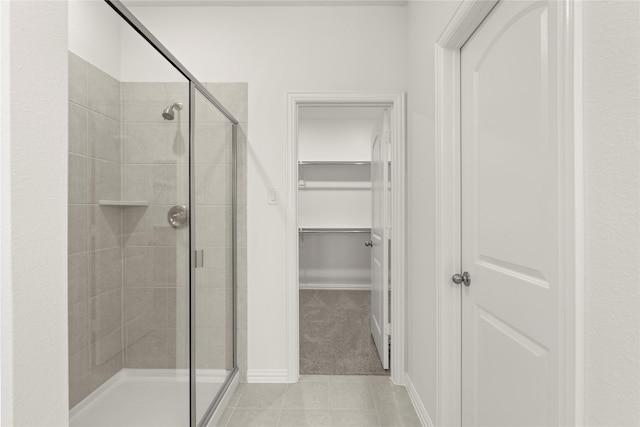 279 Bright Alcove Ct, Lavon, TX 75166 - bathroom with a stall shower, tile patterned floors, a walk in closet, and baseboards