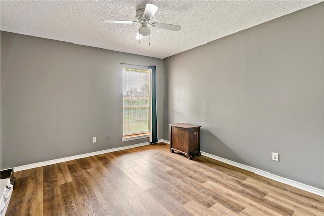 unfurnished room featuring a textured ceiling, light wood finished floors, a ceiling fan, and baseboards