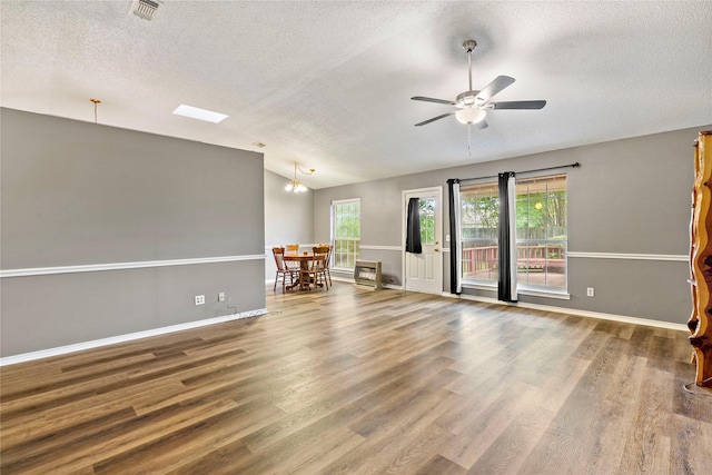 empty room with vaulted ceiling, wood finished floors, visible vents, and a ceiling fan