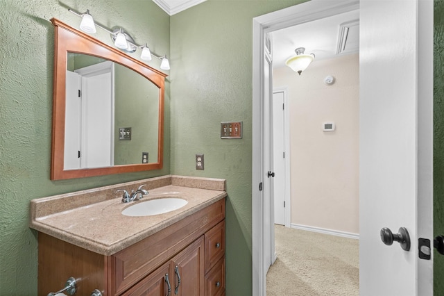 bathroom with a textured wall, vanity, and baseboards