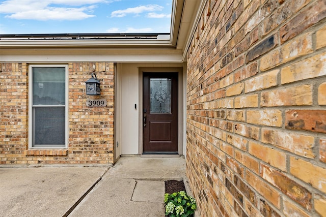 view of exterior entry with brick siding