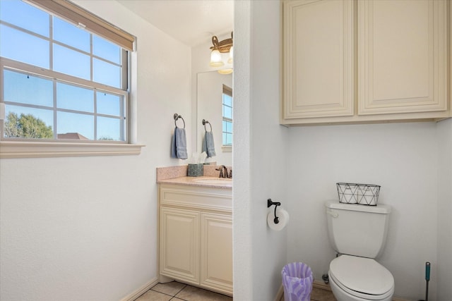 bathroom featuring toilet, tile patterned floors, baseboards, and vanity