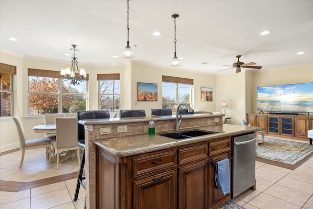 kitchen with light tile patterned floors, a kitchen island with sink, stainless steel dishwasher, and a sink