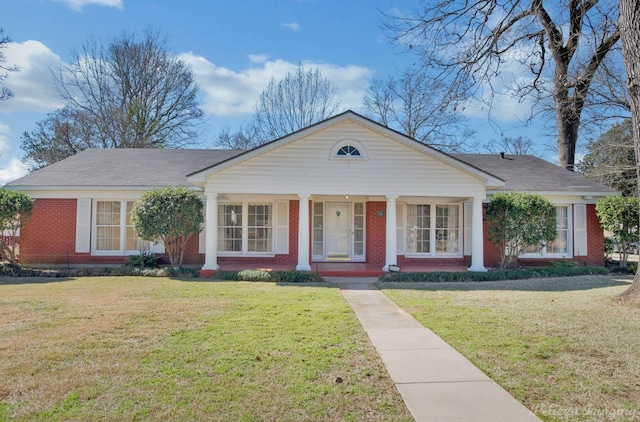 view of front facade featuring brick siding, a front lawn, and a porch