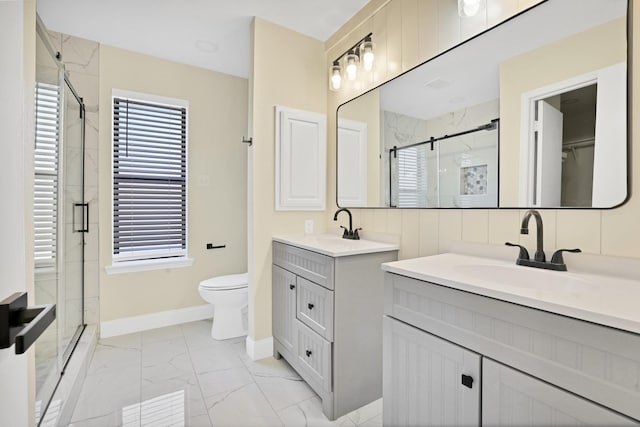 full bathroom with a sink, plenty of natural light, marble finish floor, and a stall shower