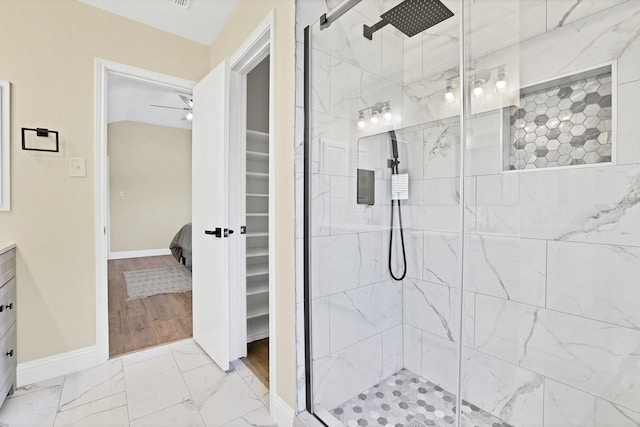 bathroom with marble finish floor, a shower stall, baseboards, ceiling fan, and vanity