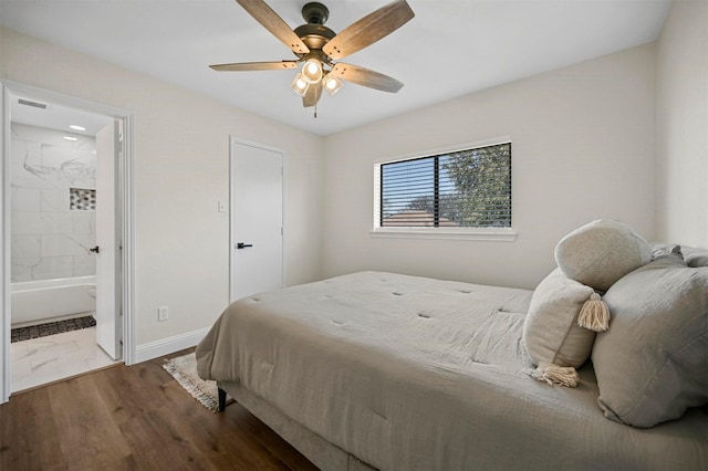 bedroom with visible vents, ensuite bathroom, wood finished floors, baseboards, and ceiling fan