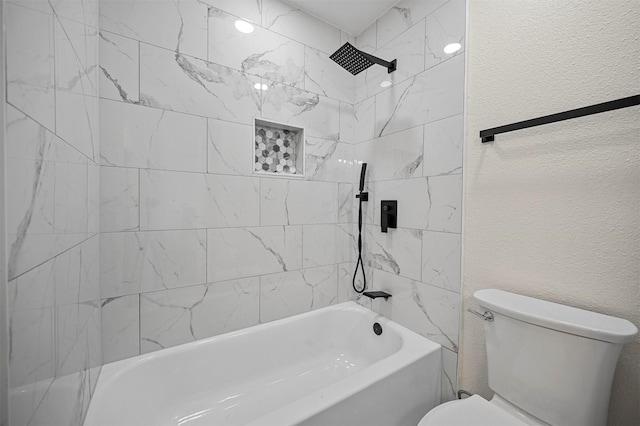 full bathroom featuring shower / bathing tub combination, toilet, and a textured wall