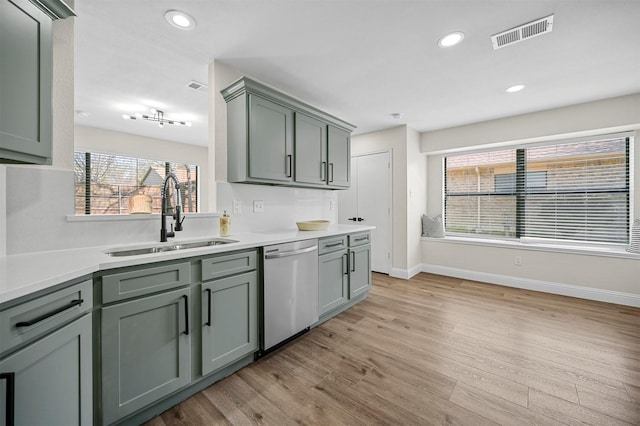 kitchen featuring visible vents, a sink, light wood-style floors, light countertops, and dishwasher