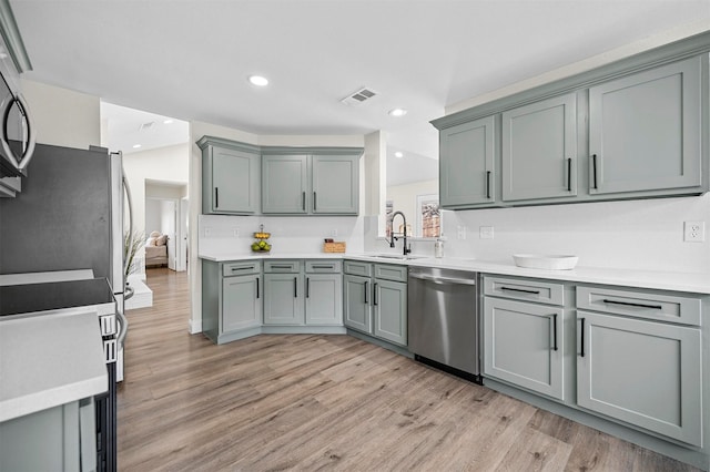 kitchen with light wood-type flooring, visible vents, appliances with stainless steel finishes, and a sink