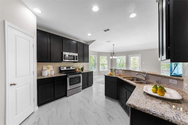 kitchen with dark cabinets, visible vents, marble finish floor, appliances with stainless steel finishes, and decorative backsplash