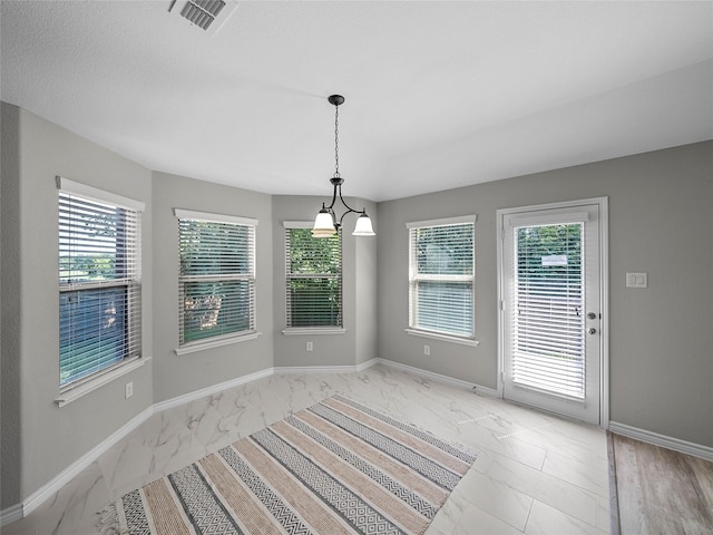 unfurnished dining area featuring marble finish floor, baseboards, and visible vents