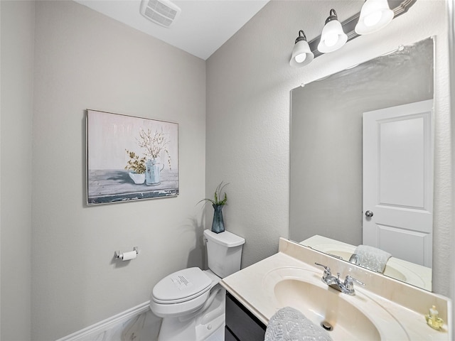 bathroom featuring baseboards, visible vents, vanity, and toilet