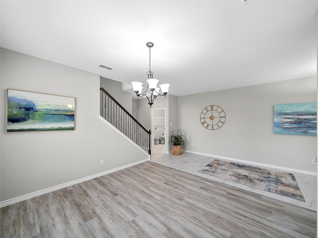 foyer entrance with visible vents, stairway, light wood-style floors, a chandelier, and baseboards