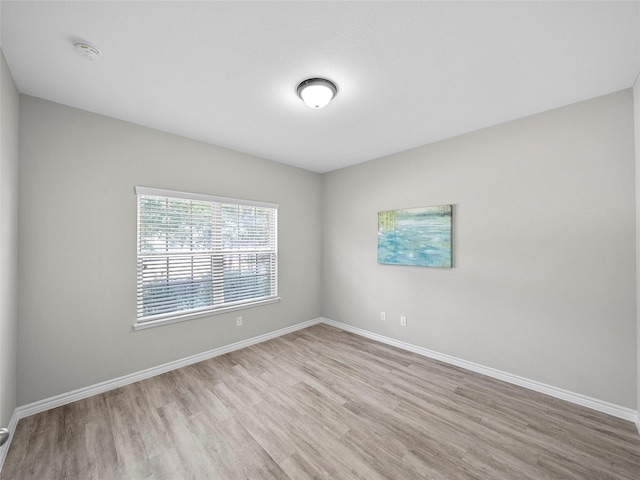 unfurnished room featuring light wood-type flooring and baseboards